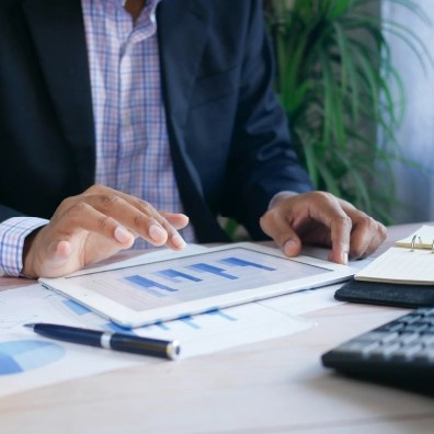 Man looking at financial charts on a tablet.