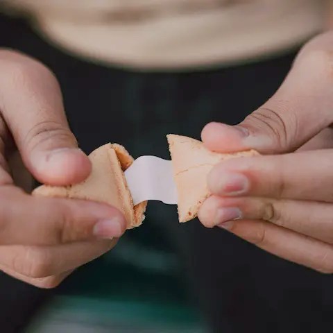 Person opening up a fortune cookie