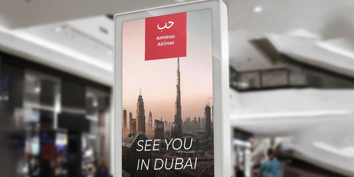Digital display in a shopping mall showing a travel ad with the message 'See You in Dubai'.